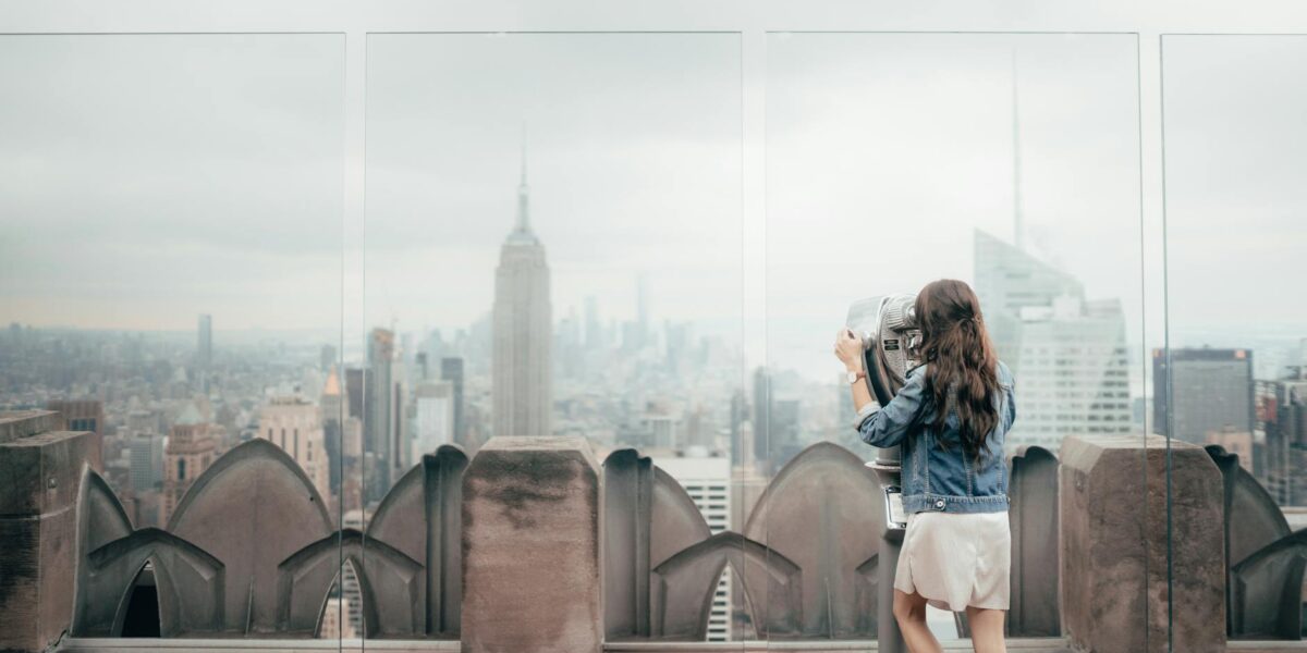 woman in blue denim jacket standing on top of building