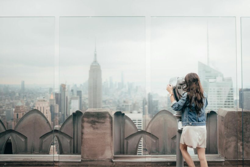 woman in blue denim jacket standing on top of building